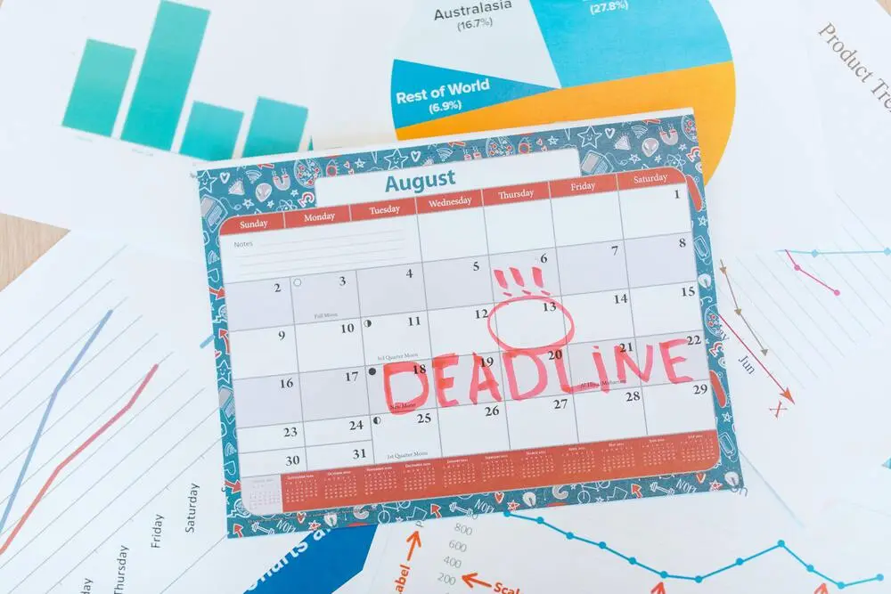 imagem com um calendário sobre a mesa com uma data marcada em vermelho com a palavra Deadline